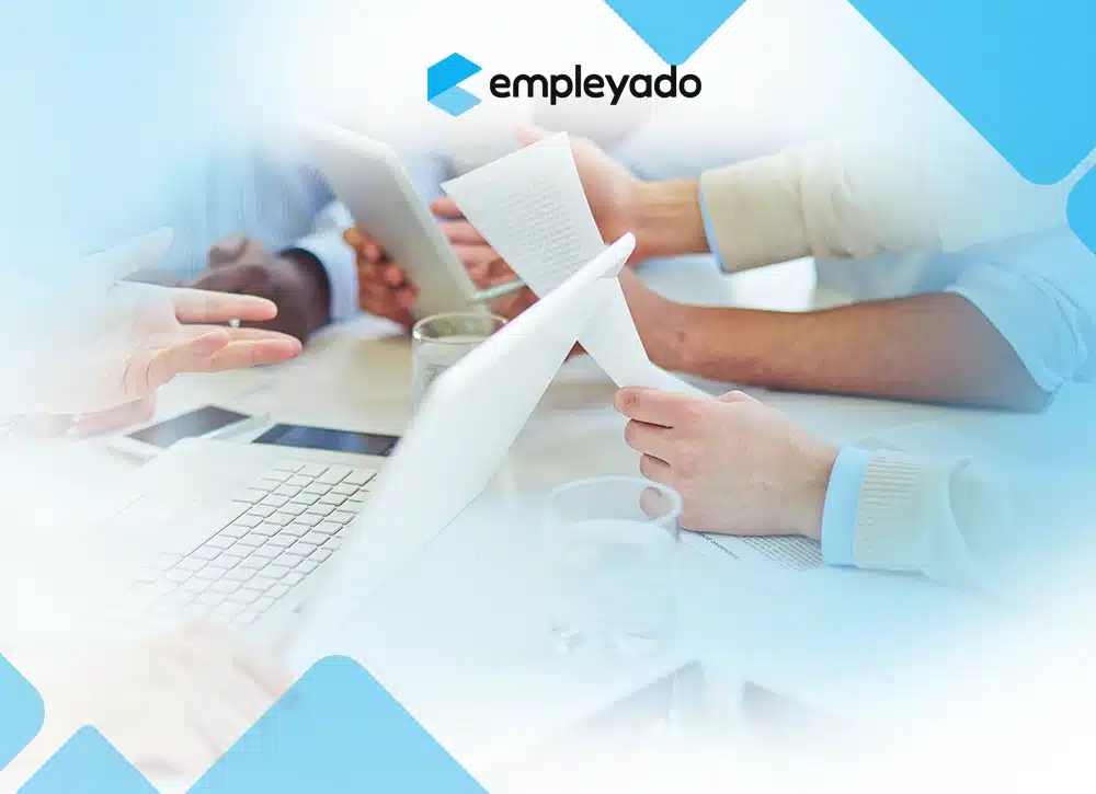 Team members reviewing performance documents and data during a collaborative meeting—representing modern culture-based performance evaluation in the workplace.