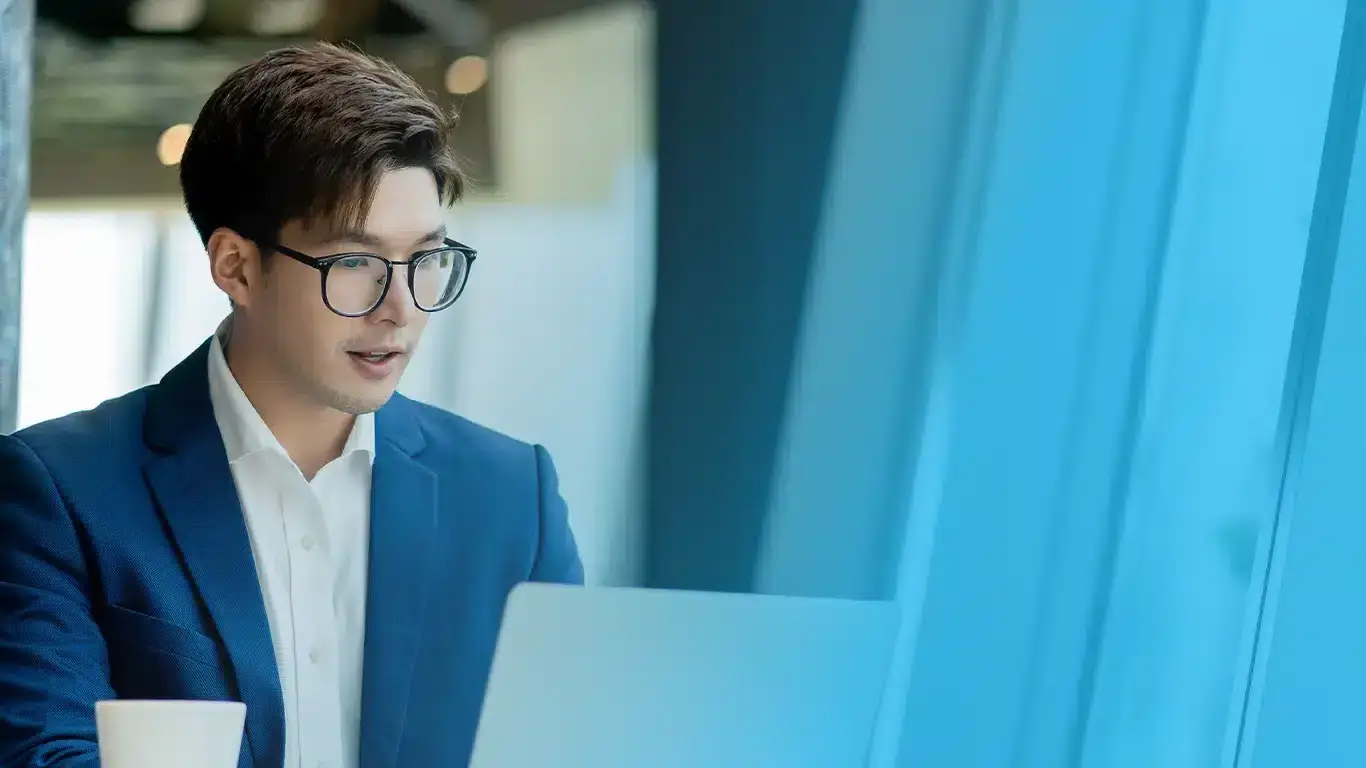 Professional employee working on a laptop in a modern office, representing seamless and efficient employee management with empleyado's smart HR solutions.